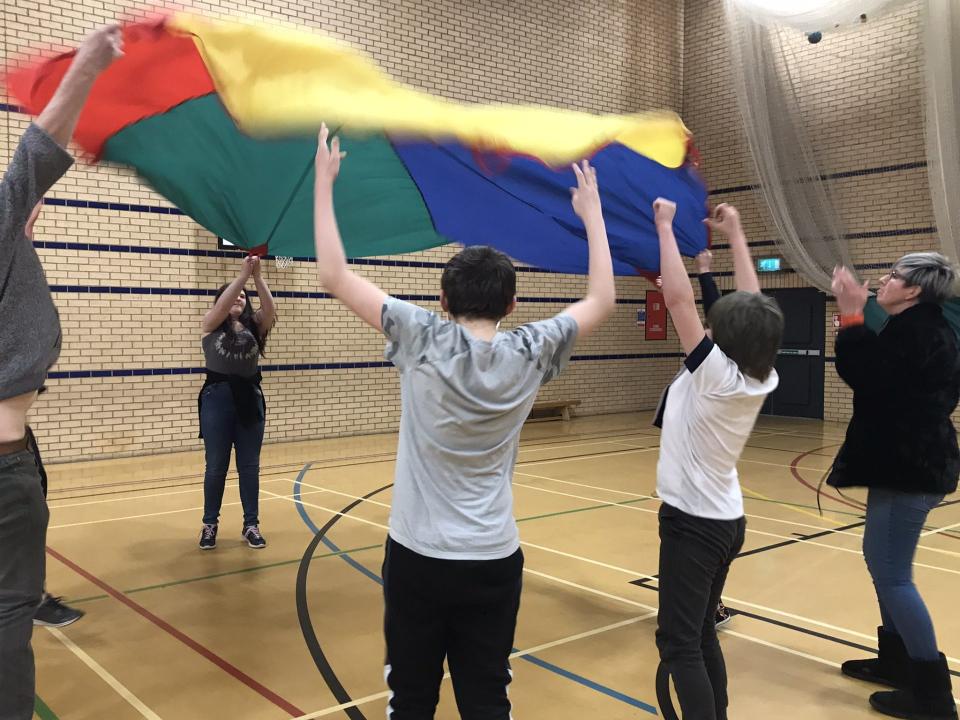 Group playing with colorful parachute